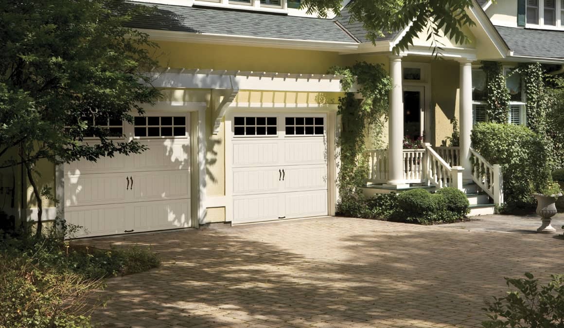 white garage doors on a yellow house