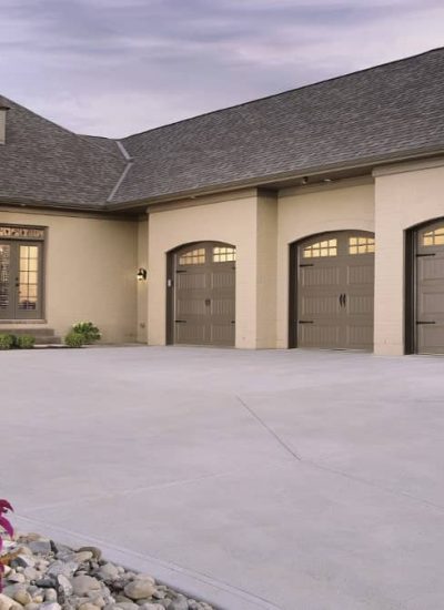 three gray garage doors with windows