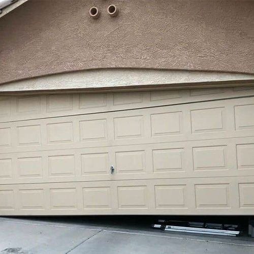 an off track garage door with one side on the ground and the other in the air