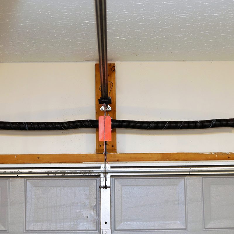 A close up image of a the springs on a overhead garage door opener